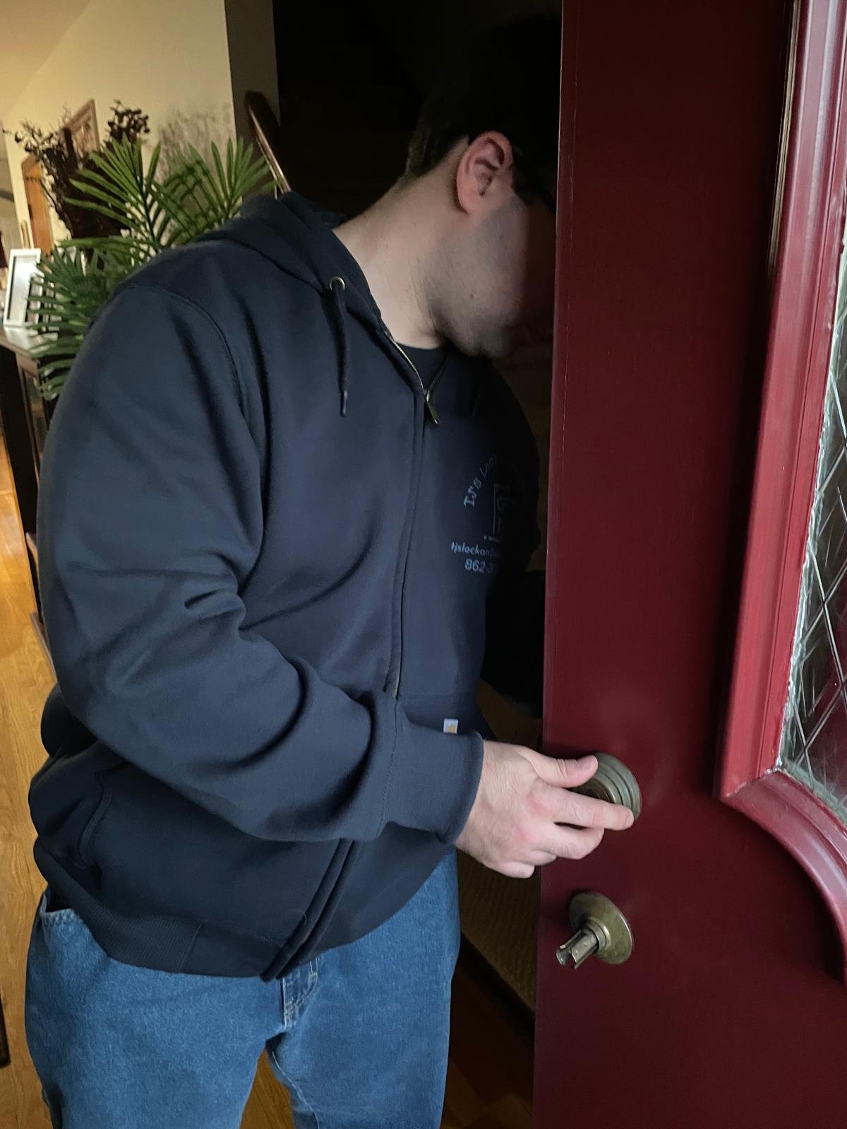 Locksmith repairing a residential door lock